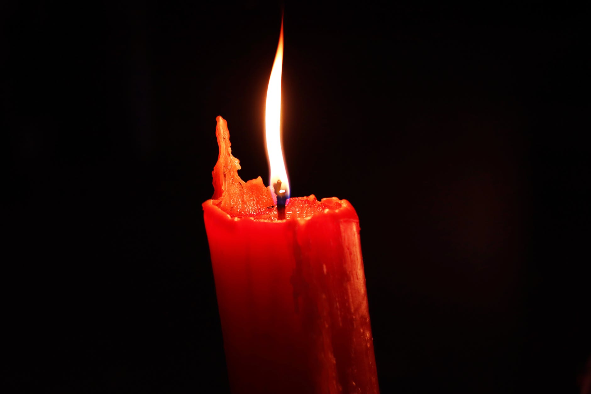 red pillar candle with black background